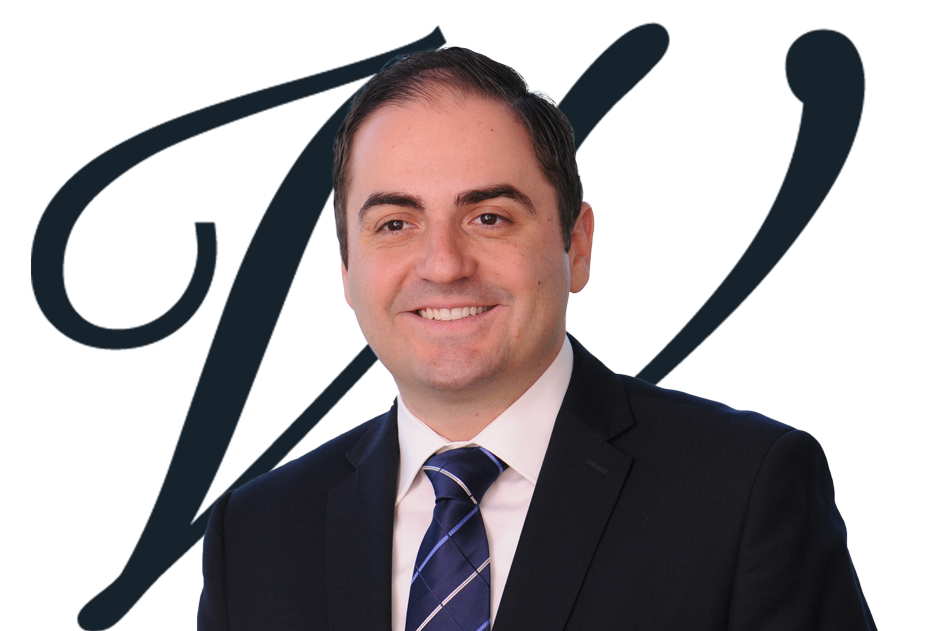 Portrait of Gianni Figliomeni-Partner at Wilson Chartered Professional Accountants, taken shoulders up with him smiling while in a suit and tie and company logo